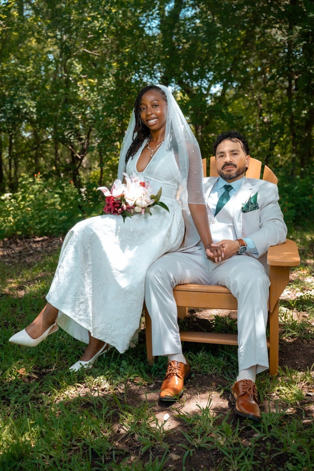 Bride with a floral bouquet seated beside the groom on a wooden chair for a relaxed outdoor wedding portrait in Austin, Texas.