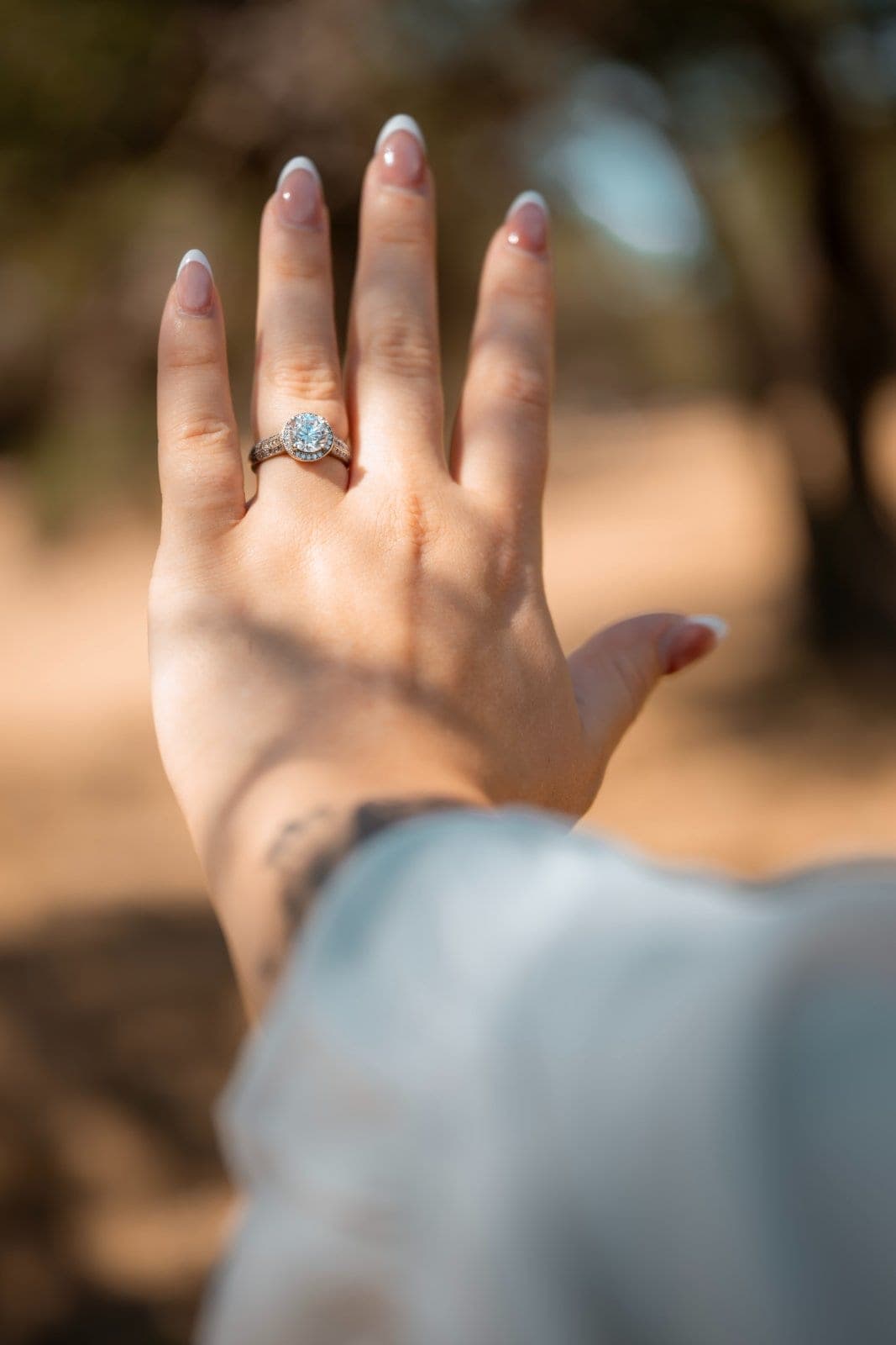 Close-up of an engagement ring on a woman's hand during an outdoor proposal session in Burnet, Texas.
