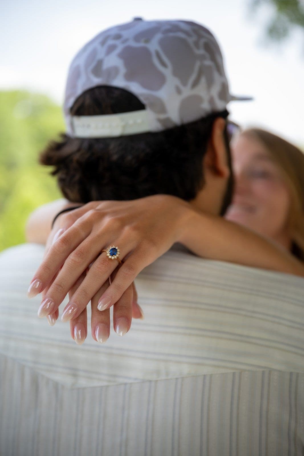 Close-up of an engagement ring as a newly engaged couple embraces after a surprise proposal in Austin, Texas.