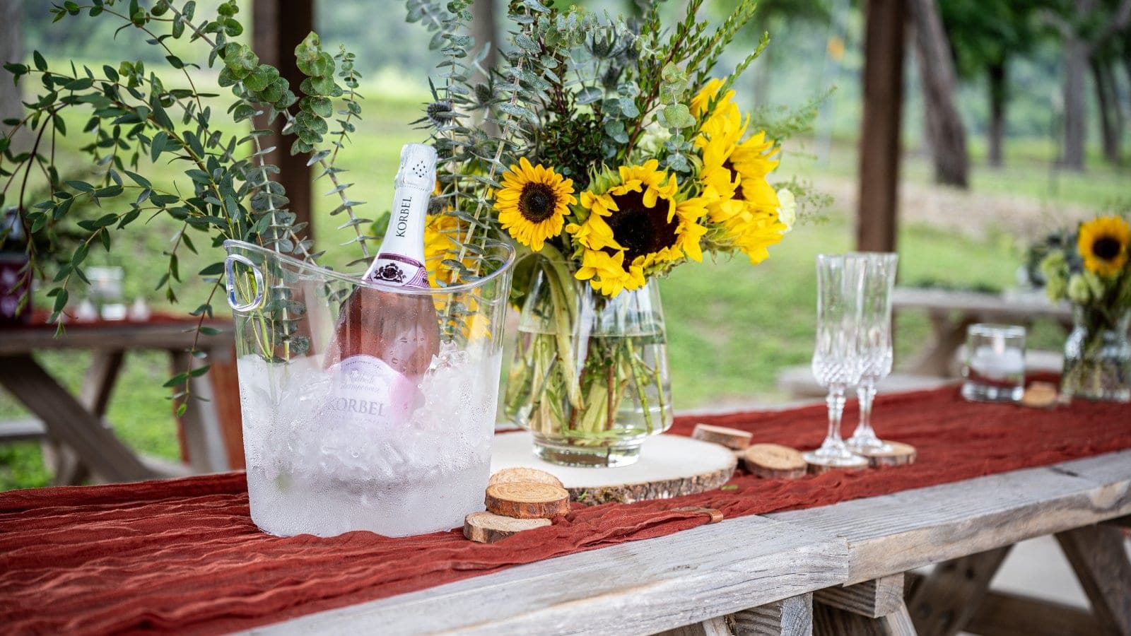 Romantic proposal table decor with sunflowers, champagne, and floral arrangements photographed during a surprise proposal in Austin, Texas.